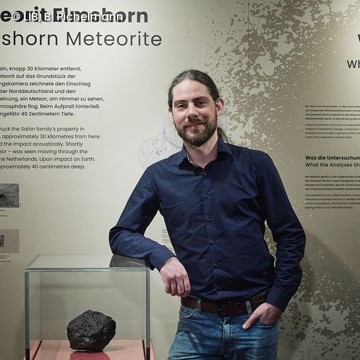 Meteoritenforscher Dr. Stefan Peters neben dem Meteoriten